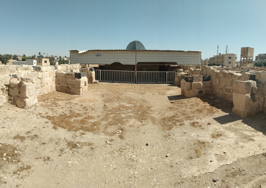 The mosque is covered and a silhouette shows where the dome would have been. Note the large square cut stones that supported arches.